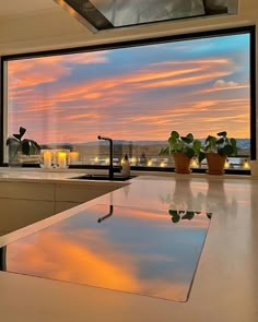 a kitchen with a large window that looks out onto the city at sunset or dawn