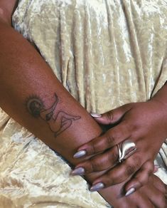 a woman's arm with a tattoo on it and her hand holding the other arm