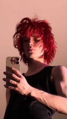 a man with red hair taking a selfie in front of a mirror while holding his cell phone