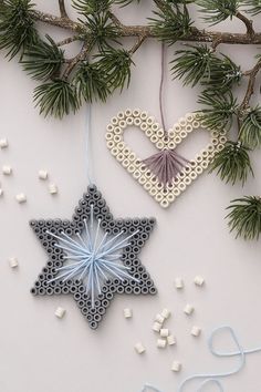 an ornament hanging from a tree branch next to other ornaments on the table