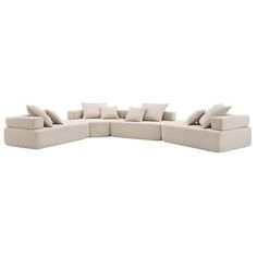 a large sectional couch with pillows on it's back and side facing the camera