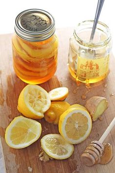 sliced lemons and honey sit on a cutting board next to a jar of honey