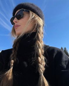 a woman with long blonde hair wearing sunglasses and a beanie on top of her head