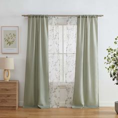 a living room with a plant and window curtain in it's centerpieces