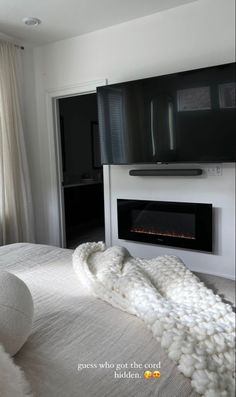 a bedroom with a fireplace and white bedding