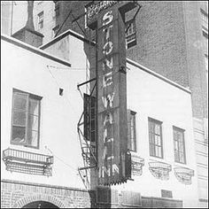 an old black and white photo of a building with a large sign on it's side