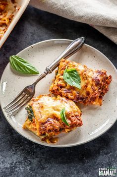 two pieces of lasagna on a plate with a fork