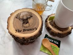 two wooden coasters sitting on top of a table next to a cup and tea bag