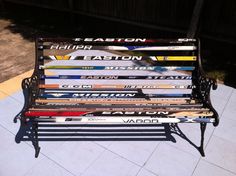 a bench made out of skis sitting on top of a tiled floor next to a fence