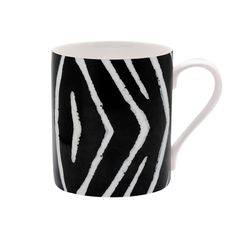 a black and white coffee mug with wavy lines on the outside, in front of a white background