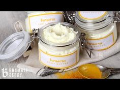 four jars of white stuff sitting on top of a table next to spoons and spices