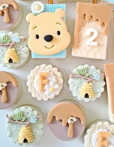 there are many decorated cupcakes on the table with bear and honeycomb decorations