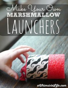 a kid is playing with some red and black paper roll crafts that are made from marshmallows