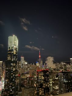 the city skyline is lit up at night, with skyscrapers in the foreground