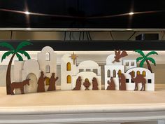 the nativity scene is made out of paper and cutout with palm trees on top