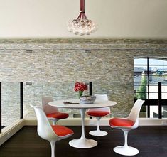 an image of a dining room setting with red chairs and white table in the middle