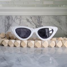 a pair of white sunglasses sitting on top of a counter next to some cubes