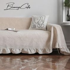 a couch with a pillow on it in front of a wall that says blooming crafts