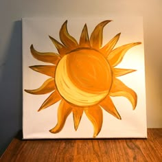 an acrylic painting of a yellow sun on a white canvas with wood flooring