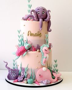 a three tiered cake with an octopus and sea animals on it's side