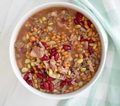 a white bowl filled with beans and meat