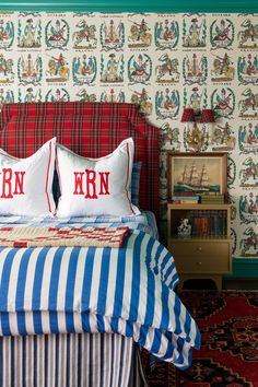 a bed with two pillows sitting on top of it next to a book shelf and dresser