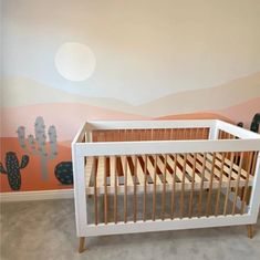 a baby crib in front of a painted desert scene