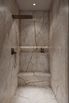 a walk in shower sitting next to a tiled floor and wall with lights on the ceiling