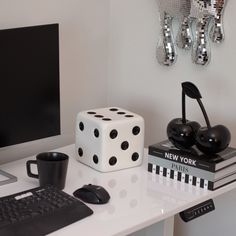 a desk with a computer, keyboard and dice on it