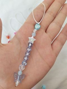 a hand holding a small glass beaded necklace