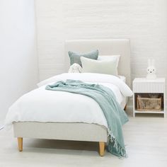 a white bed with pillows and blankets on it