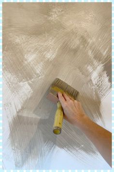 a person using a brush to paint a wall