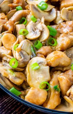 chicken and mushroom stir fry in a skillet with green onions, mushrooms, and scallions