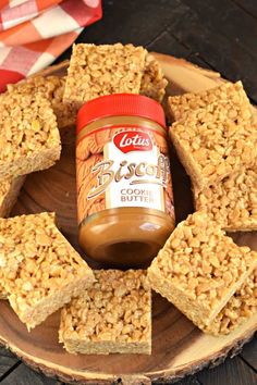 peanut butter and oatmeal bars on a wooden plate with a jar of peanut butter