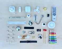 an assortment of electronic gadgets and accessories laid out on a wooden surface, including remote controls