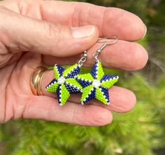 Be the star that you and your team are with these fun 3 dimensional star earrings! Show your team spirit with these super lightweight fun earrings!  They are made with Delica beads in navy and lime green and are highlighted with pearl white beads.  They are about the size of a quarter and take me about 2 hours to make a pair. If you have friends who like a different team and would like to give them a gift, I can make these in any team colors! Navy Earrings, Football Earrings, Delica Beads, White Beads, Fun Earrings, Star Earrings, Team Colors, Lime Green, Pearl White