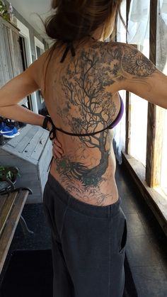 a woman with a tree tattoo on her back