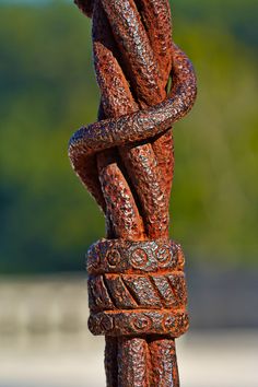 an old rusted metal pole with chains attached to it