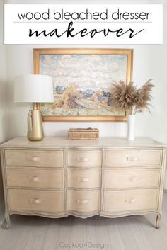 a white dresser sitting next to a painting on the wall