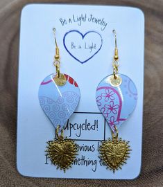 two heart shaped earrings on top of a white card with the words, be a light journey