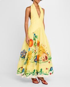 a woman wearing a yellow dress with flowers on it