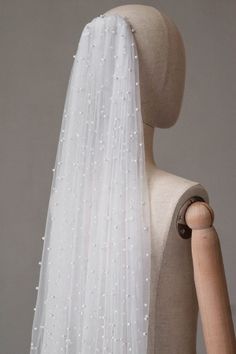 a mannequin with a white veil on it's head and the back of its head