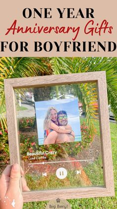 a person holding up a wooden frame with the words one year anniversary gifts for boyfriend