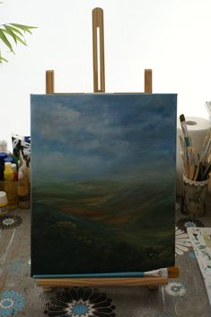 an easel sitting on top of a table next to a painting