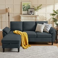 a living room scene with focus on the sofa and chair, which has a yellow throw blanket