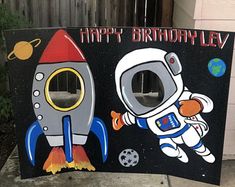 a birthday sign with an astronaut and rocket on it