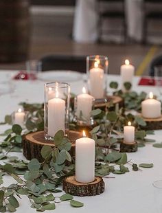 the table is set with candles and greenery