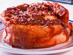 a bundt cake with pecans on top sitting on a blue and white plate