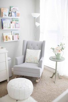 a baby's room with a chair, table and pictures on the wall