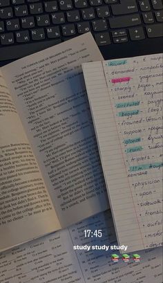 an open book sitting on top of a desk next to a keyboard